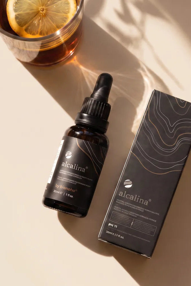 alcalina dropper bottles on a warm cream surface with a long soft shadow