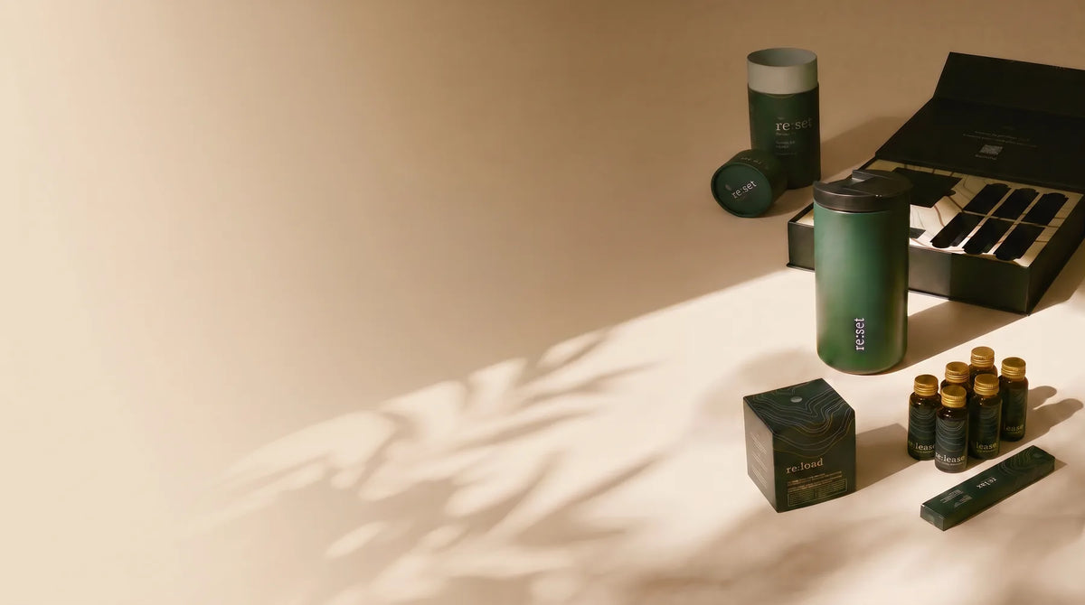 The re:set kit with bottles, sachets and its box on a cream surface.