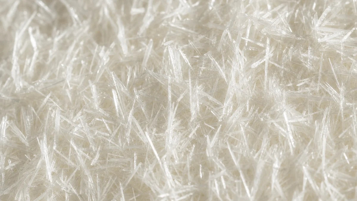 Anhydrous caffeine, a dense mat of long white needle crystals